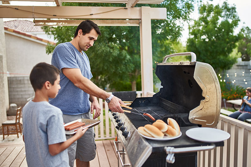 Father grilling with son